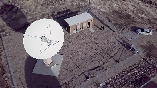 Aerial view of a large satellite dish on a ground installation.